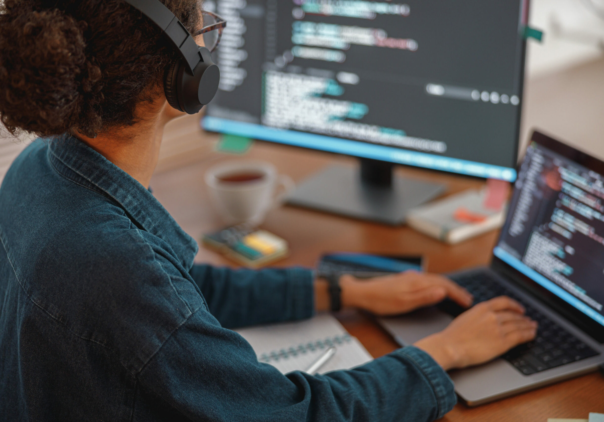 Woman in headphones freelance data scientist work remotely at home. Back view